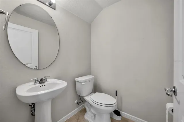 a bathroom with a sink toilet and a mirror