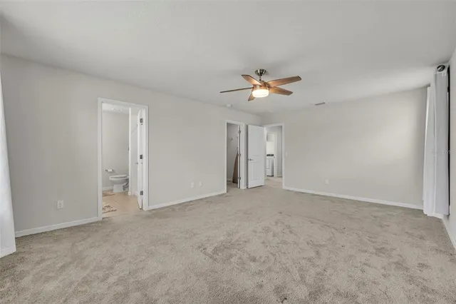 a view of an empty room with a ceiling fan