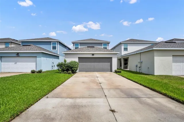 a front view of a house with a yard and garage