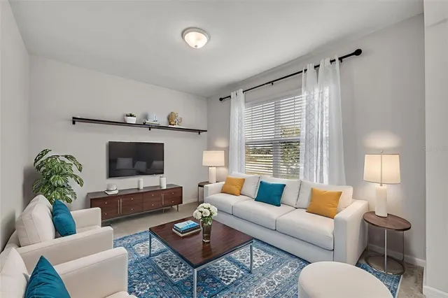 a living room with furniture a flat screen tv and a large window