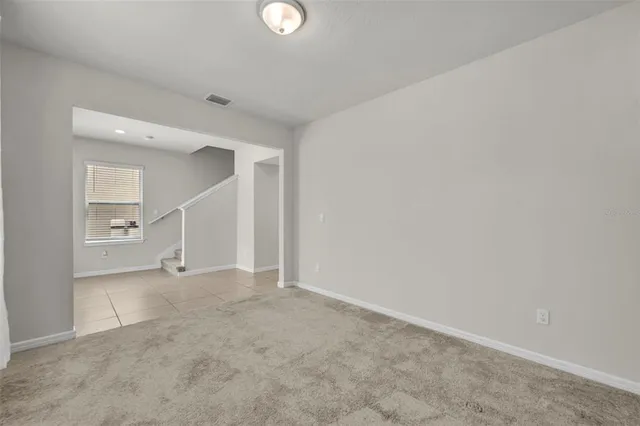 an empty room with staircase and white walls