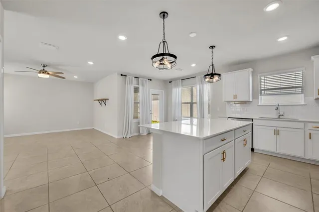 a kitchen with kitchen island granite countertop a sink cabinets and stainless steel appliances