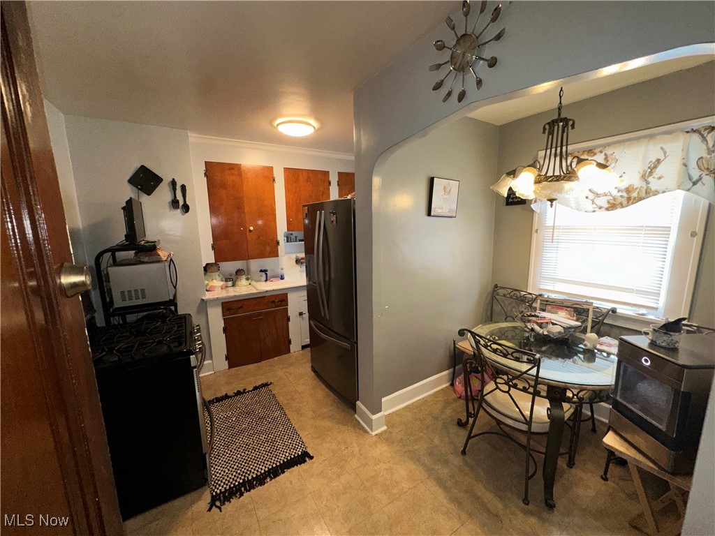 18007 Neff Road Cleveland, OH 44119 - Photo 6 of 29 Kitchen featuring a chandelier, refrigerator, hanging light fixtures, and black range with gas stovetop
