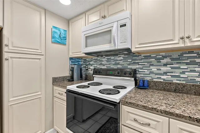 a kitchen with stainless steel appliances granite countertop a stove microwave and cabinets
