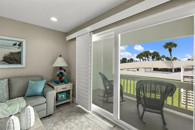 a living room with furniture a rug and a floor to ceiling window