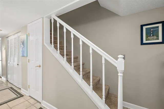 a view of staircase with lots of frames on wall and wooden floor