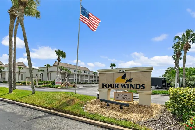 a sign board with buildings in the background