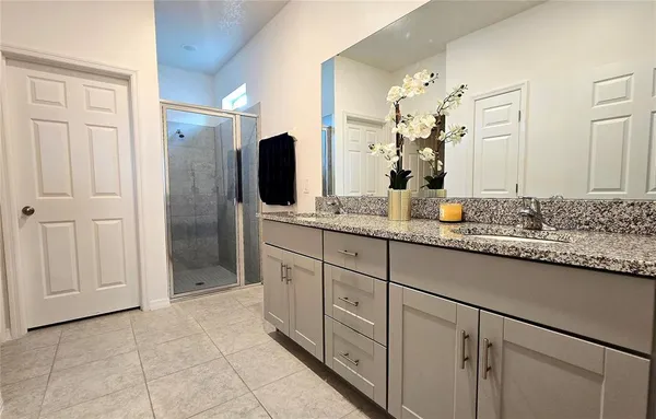 a spacious bathroom with a granite countertop sink mirror and shower