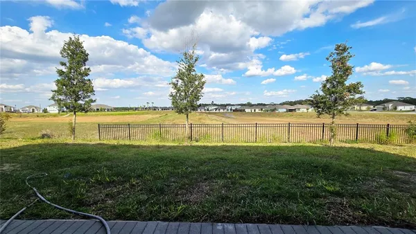 a view of a house with pool and a yard