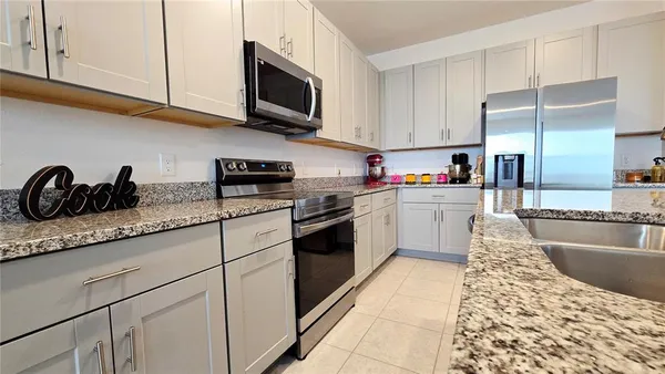 a kitchen with granite countertop a sink stainless steel appliances and cabinets