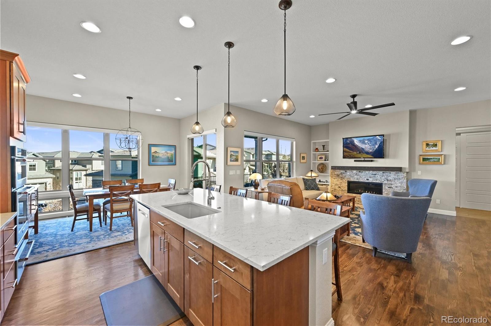 493 Meadowleaf Lane Highlands Ranch, CO 80126 - Photo 11 of 48 an open kitchen with kitchen island a refrigerator a stove top oven a dining table and chairs