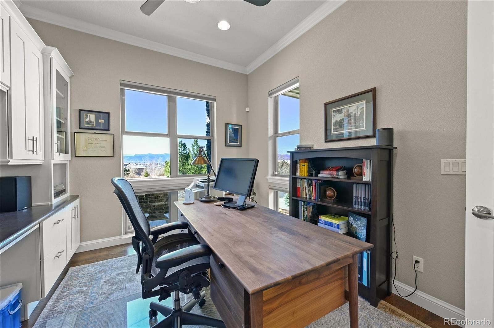 493 Meadowleaf Lane Highlands Ranch, CO 80126 - Photo 6 of 48 a view of a workspace with furniture and a bookshelf