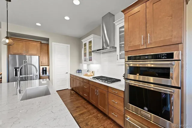 an open kitchen with kitchen island a refrigerator a stove top oven a dining table and chairs