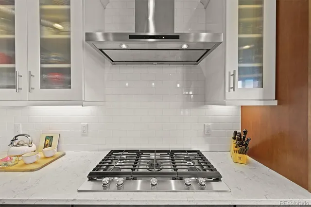 a dining room with wooden floor a chandelier a wooden table and chairs