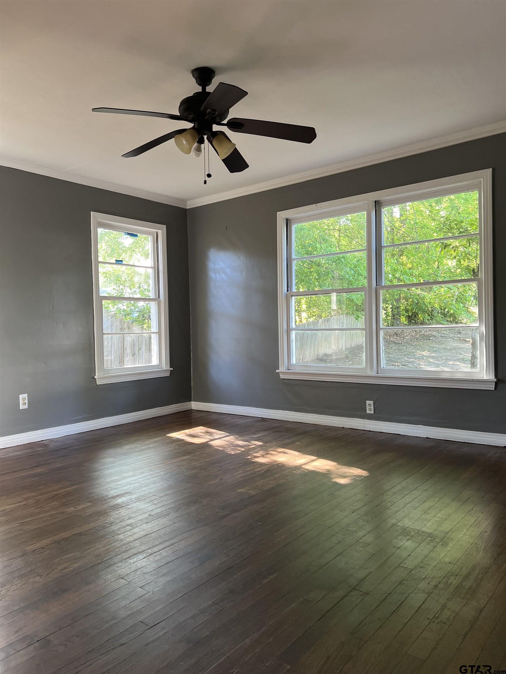 1223 South Azalea Drive Tyler, TX 75701 - Photo 5 of 11 a view of an empty room with wooden floor and a window