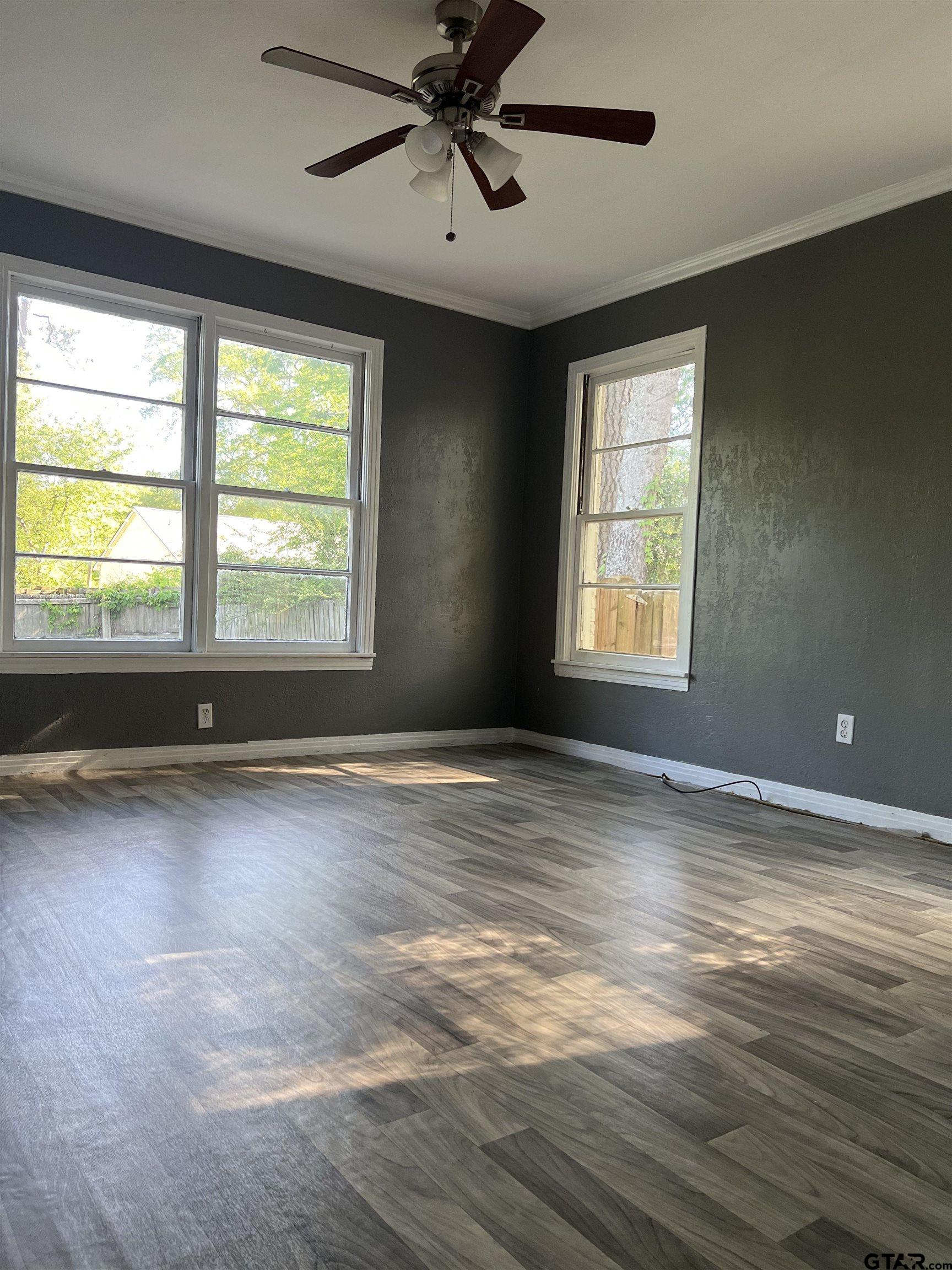1223 South Azalea Drive Tyler, TX 75701 - Photo 6 of 11 a view of an empty room with a window and wooden floor