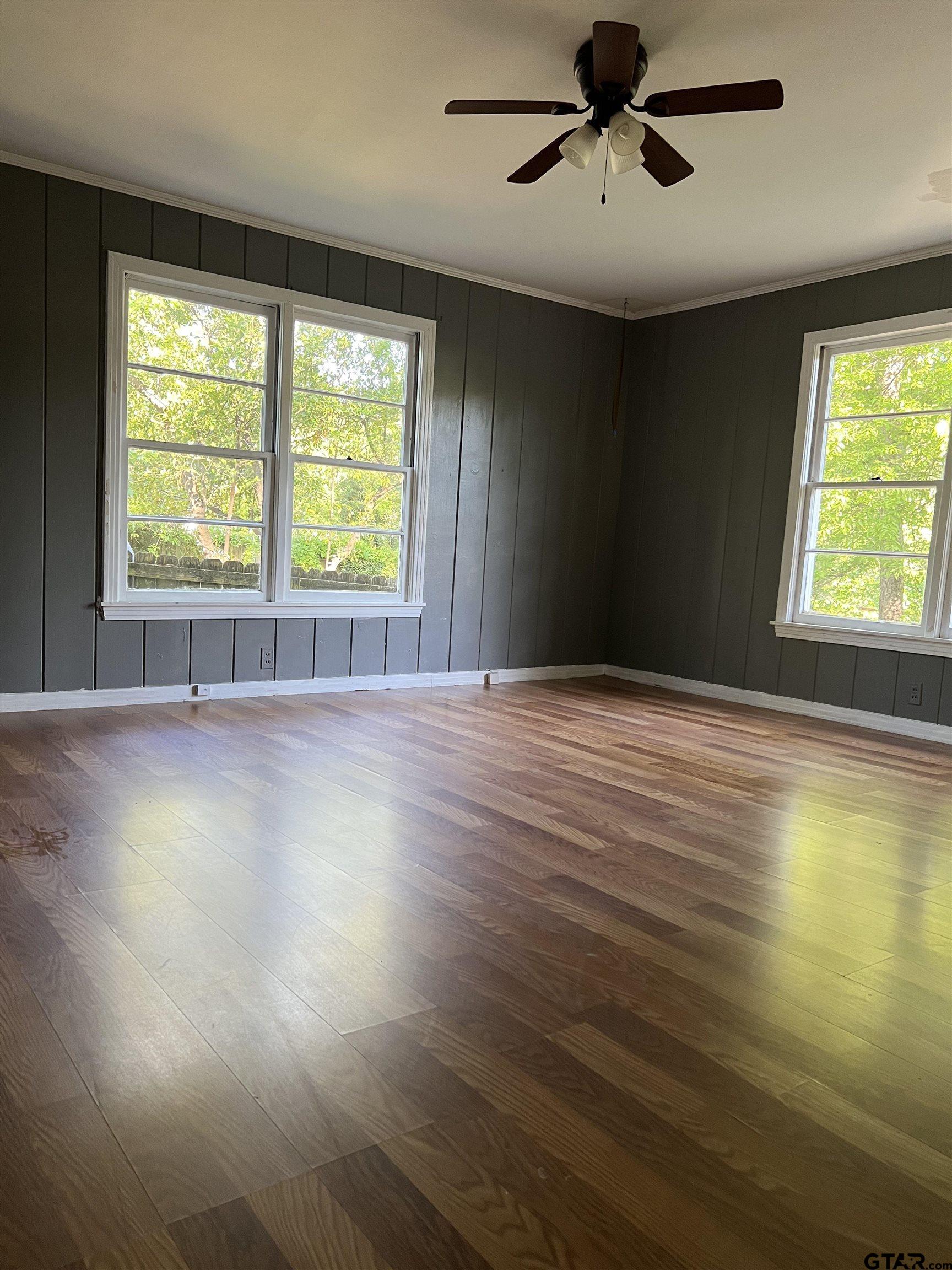 1223 South Azalea Drive Tyler, TX 75701 - Photo 7 of 11 a view of an empty room with a window and wooden floor