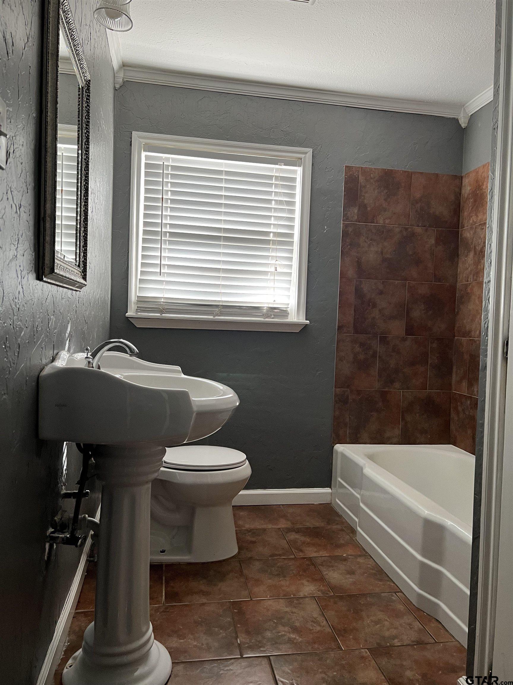 1223 South Azalea Drive Tyler, TX 75701 - Photo 9 of 11 a bathroom with a toilet a sink and bathtub