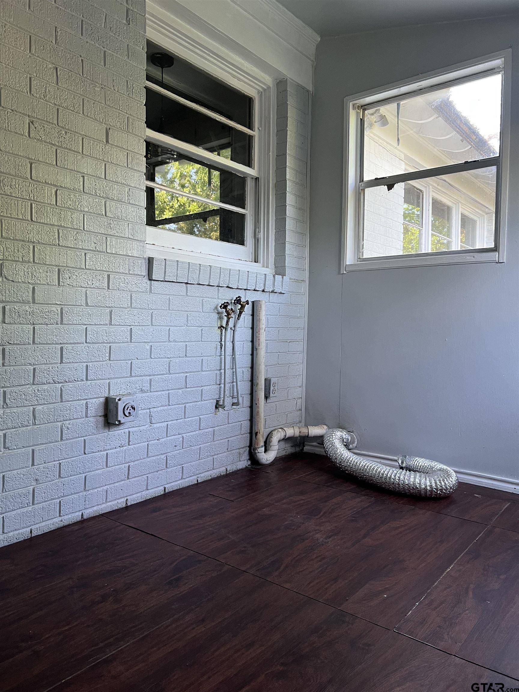 1223 South Azalea Drive Tyler, TX 75701 - Photo 10 of 11 a view of an empty room with wooden floor and a window