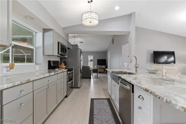 a kitchen with stainless steel appliances granite countertop a sink and a stove