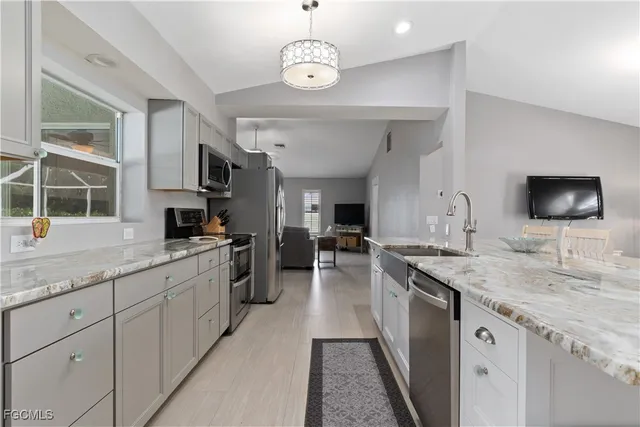 a kitchen with stainless steel appliances granite countertop a sink and a stove