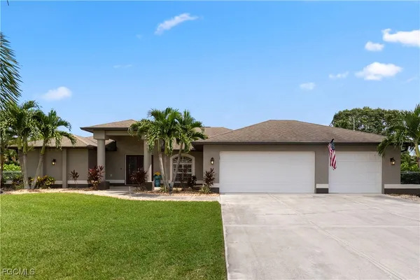 a front view of a house with a yard and palm tree
