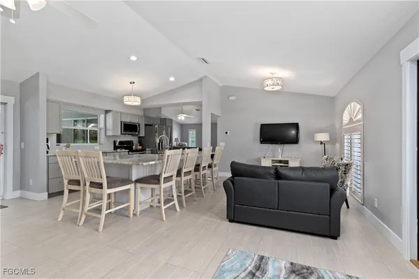 a living room with furniture a flat screen tv and a kitchen