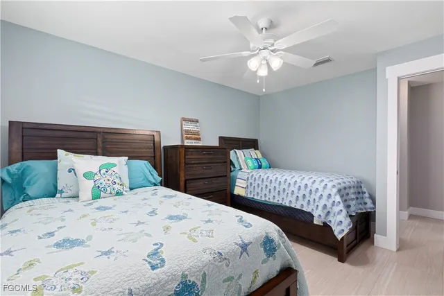 a bedroom with two beds and a chandelier