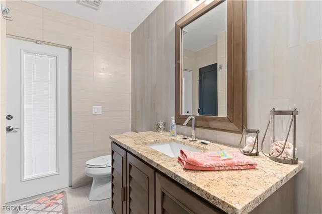 a bathroom with a granite countertop sink and a mirror