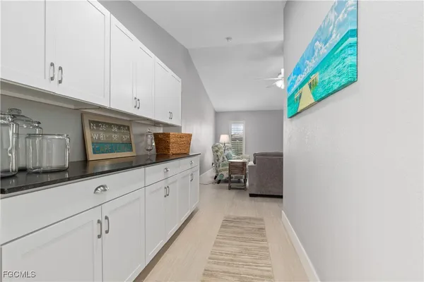 a kitchen with stainless steel appliances white cabinets and a wooden floor