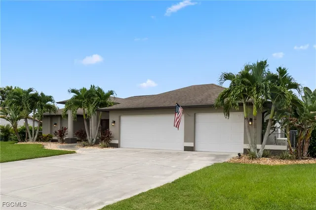 a front view of house with yard and palm tree