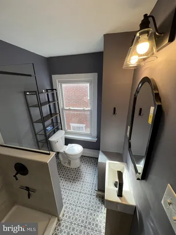 a bathroom with a toilet sink and mirror