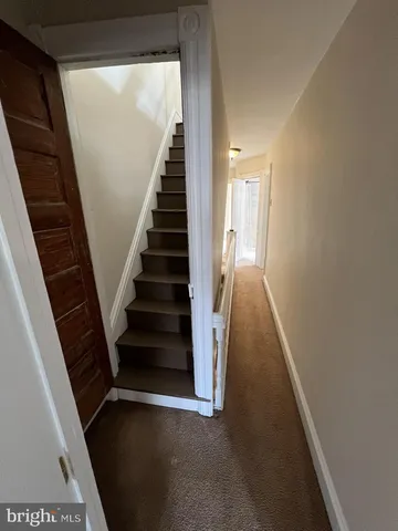 a view of a hallway with wooden floor and entryway