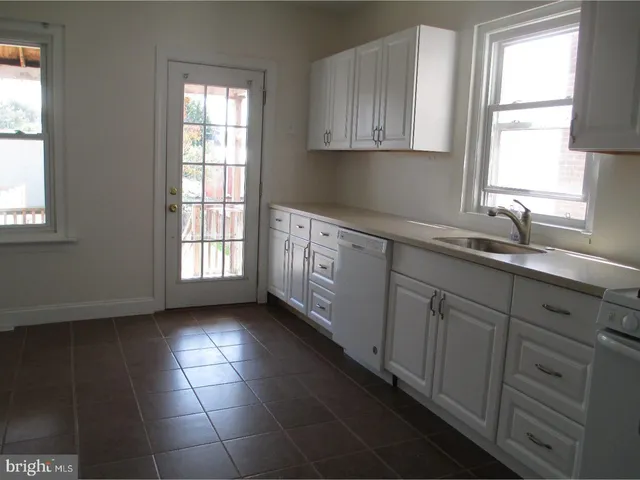 a kitchen with stainless steel appliances granite countertop a sink a window and cabinets