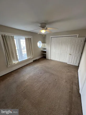 an empty room with a window and fireplace