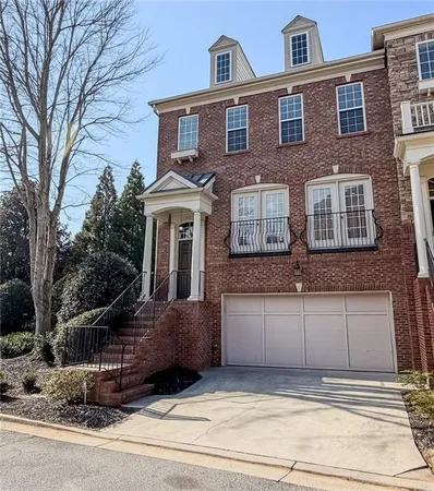 a view of a brick house with many windows and a tree