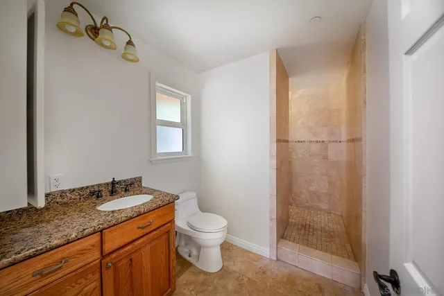 a bathroom with a granite countertop sink toilet and shower