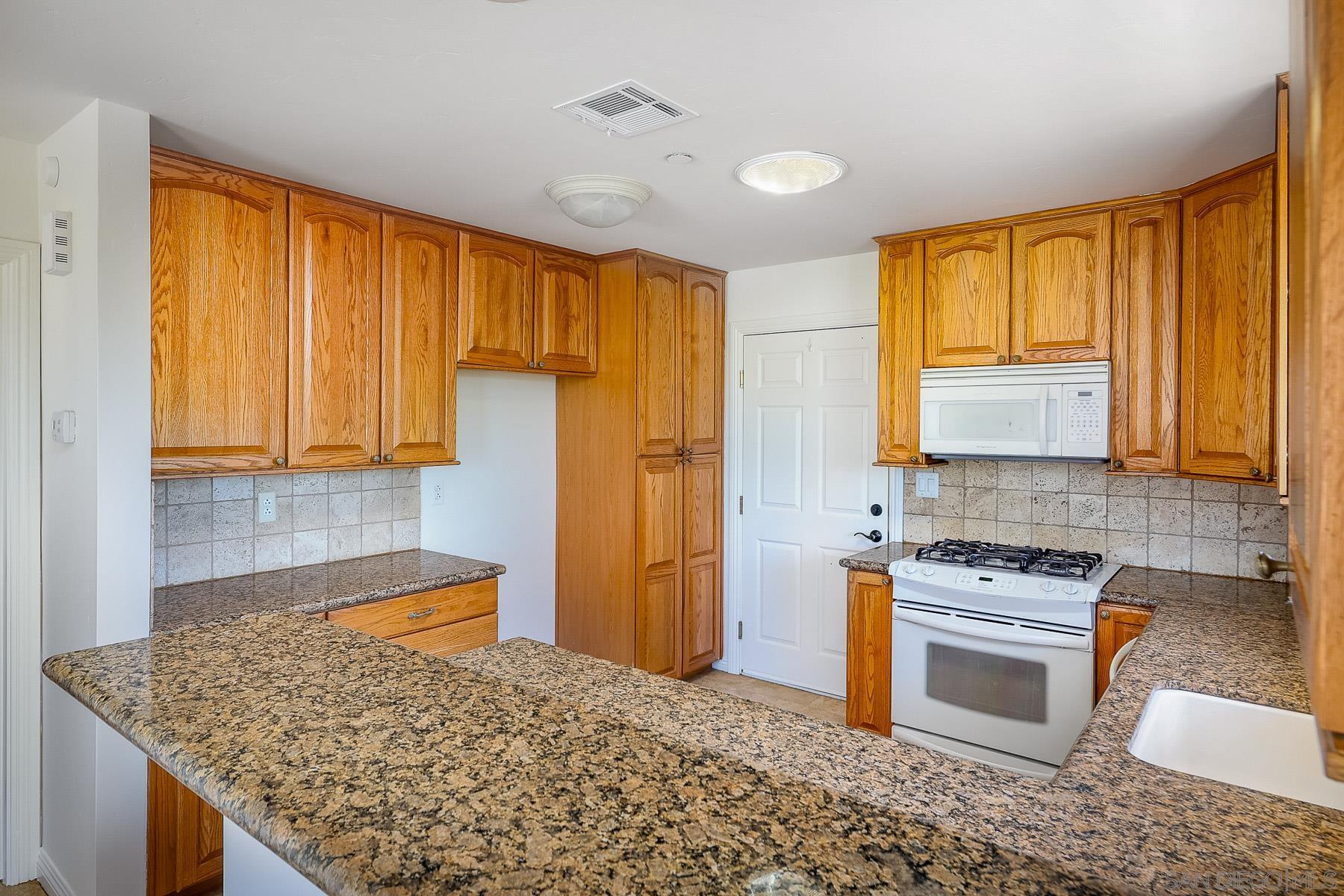 38960 Magee Road Pala, CA 92059 - Photo 7 of 25 a kitchen with stainless steel appliances granite countertop a sink stove and refrigerator