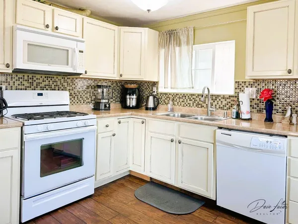 a kitchen with stainless steel appliances kitchen island granite countertop a refrigerator and microwave