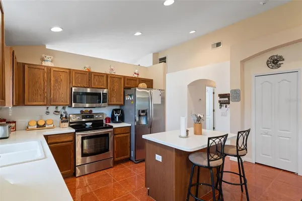 a kitchen with stainless steel appliances granite countertop a sink and a refrigerator