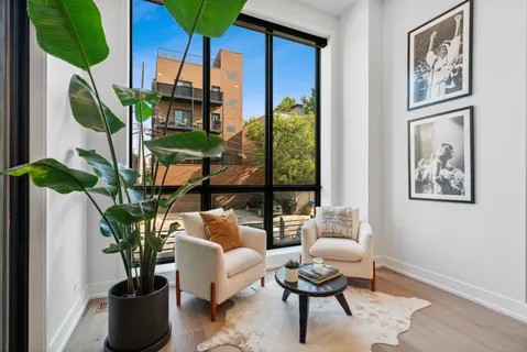 a living room with patio furniture and a potted plant
