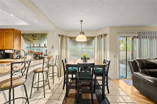 a dining hall view with a dining table chairs and white walls