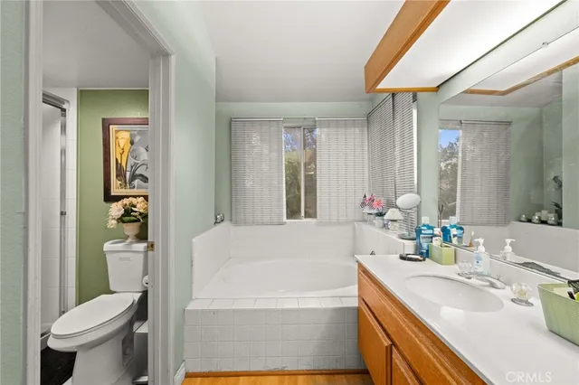 a bedroom with a bed a couch and a flat screen tv