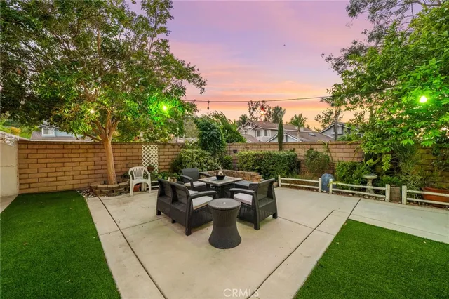 a view of a patio with table and chairs with wooden floor and fence
