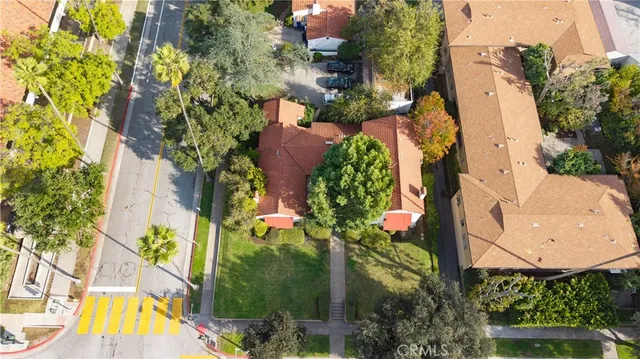 an aerial view of a house with swimming pool and large trees