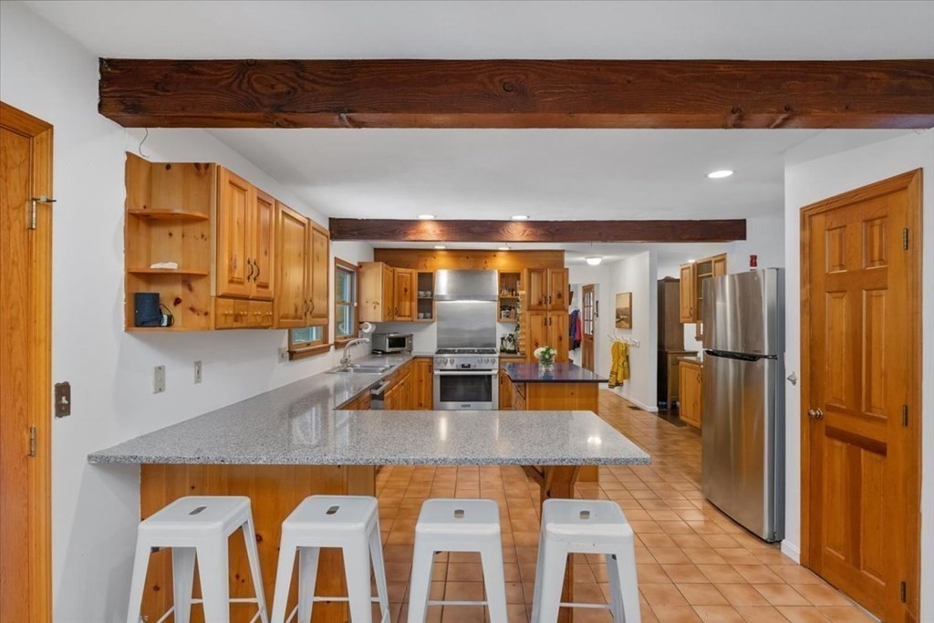 58 High Street Medfield, MA 02052 - Photo 7 of 41 a kitchen with stainless steel appliances granite countertop a sink and a refrigerator