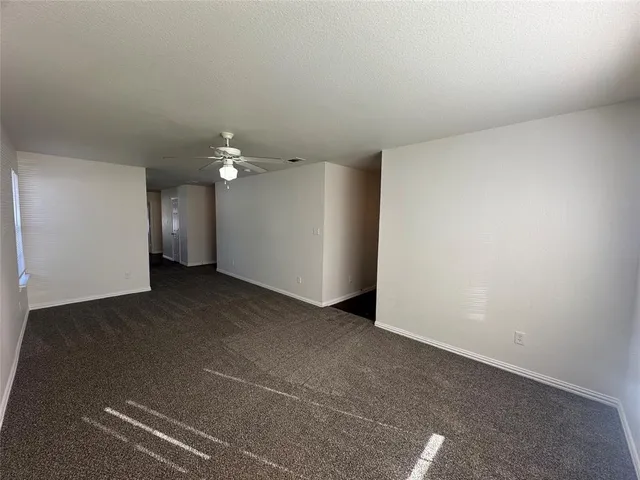 a view of a livingroom with a ceiling fan and window