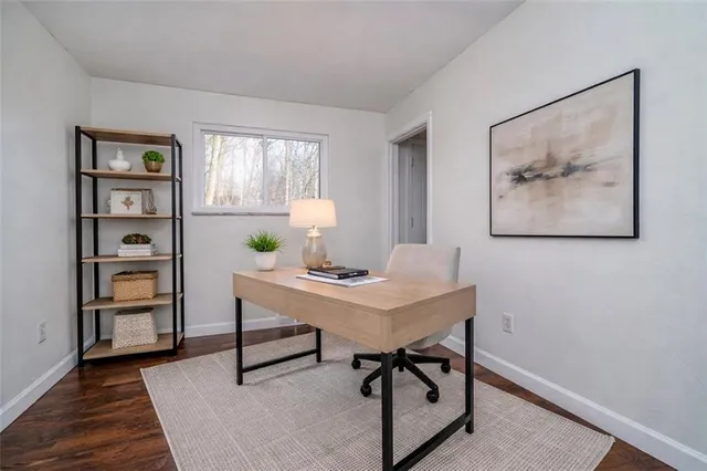 a view of a workspace with furniture and a window
