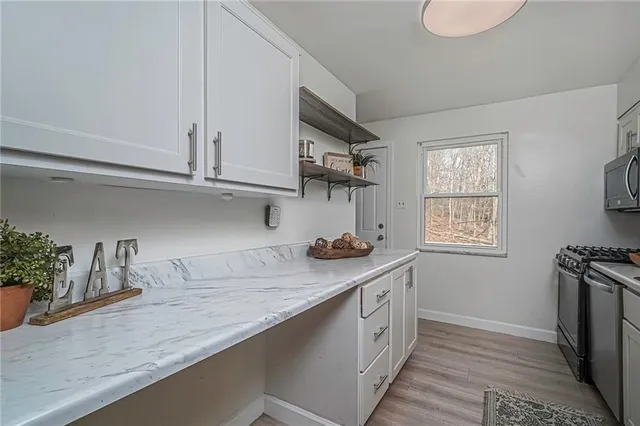 a kitchen with stainless steel appliances granite countertop a sink stove and cabinets