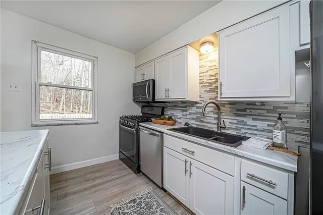a kitchen with a sink stove top oven and cabinets